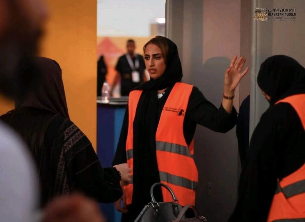 Female security officer guiding visitors at an event entrance